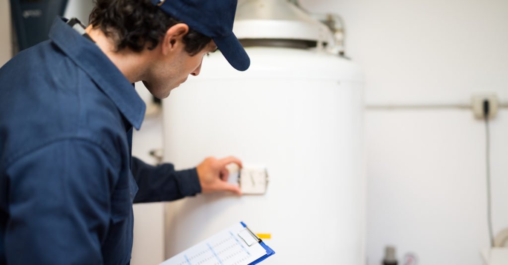 technician checking water heater gauge