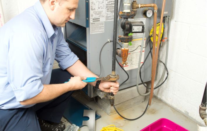 repair man fixing a gas furnace