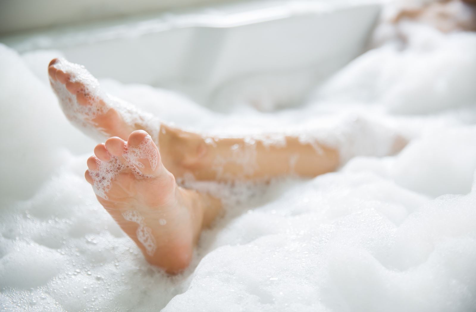 Person taking a hot bath with water from a tankless water heater.