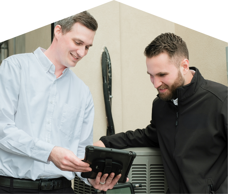 A Limcan technician in a white shirt shows service details on a tablet to a smiling client in a black jacket, standing beside an AC unit outside a beige building. A Limcan technician in a white shirt shows service details on a tablet to a smiling client in a black jacket, standing beside an AC unit outside a beige building.