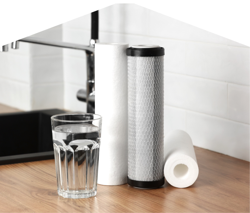 Set of Limcan water filtration cartridges placed beside a clear glass of water on a kitchen countertop, with a sink and modern faucet in the background. Set of Limcan water filtration cartridges placed beside a clear glass of water on a kitchen countertop, with a sink and modern faucet in the background.