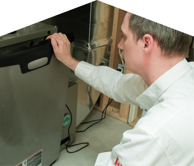Limcan HVAC professional installing a new furnace unit, aligning the front panel with surrounding ductwork and wiring in a residential utility space. Limcan HVAC professional installing a new furnace unit, aligning the front panel with surrounding ductwork and wiring in a residential utility space.