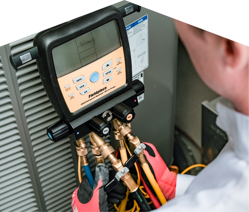 A Limcan home service crew member uses a digital manifold gauge to check refrigerant levels on an HVAC unit for service. A Limcan home service crew member uses a digital manifold gauge to check refrigerant levels on an HVAC unit for service.
