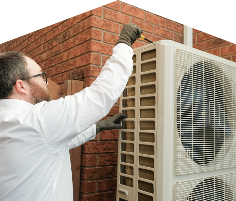 Limcan HVAC specialist using a screwdriver to complete a heat pump installation beside a brick wall. Limcan HVAC specialist using a screwdriver to complete a heat pump installation beside a brick wall.