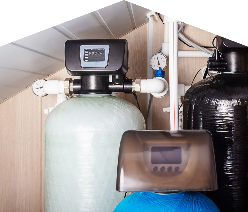 Limcan home water filtration system featuring resin tanks, digital control heads, pressure gauges, and connected piping in a utility room. Limcan home water filtration system featuring resin tanks, digital control heads, pressure gauges, and connected piping in a utility room.