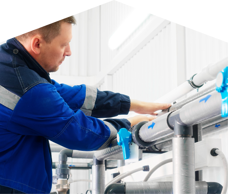 Limcan water damage and restoration specialist in a blue uniform adjusts insulated piping on a water system inside a bright utility room. Limcan water damage and restoration specialist in a blue uniform adjusts insulated piping on a water system inside a bright utility room.